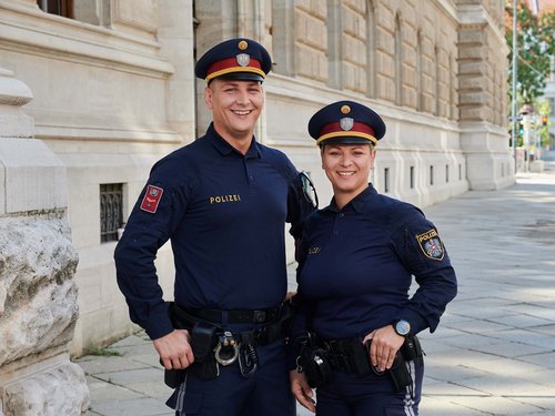 Junger Polizist vor einer Absperrung