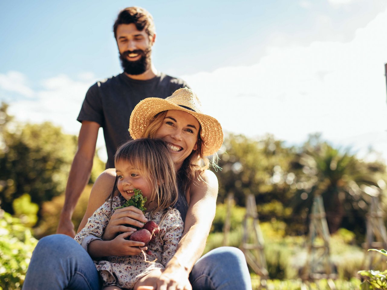 Flexibler Vermögensaufbau mit der ÖBV: Eine Familie sitzt gemeinsam im Grünen und lacht sorgenfrei in die Kamera.