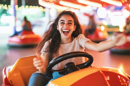 ÖBV ZukunftSicherung für junge Menschen Eine junge Frau sitzt in einem Autoscooter und lacht.