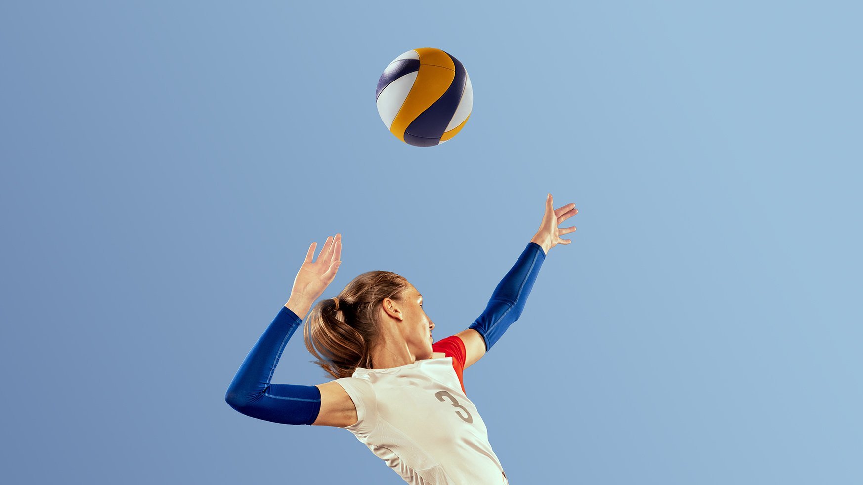 Dynamic portrait of professional volleyball player in sports uniform playing volleyball isolated on dark background. Sport, healthy lifestyle, team, action, motion concept