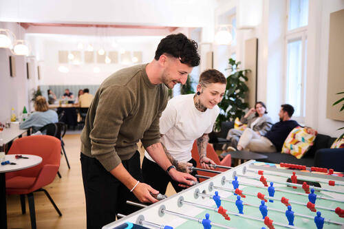 ÖBV Versicherungsmitarbeiter:innen beim Tischfußball in der Cafeteria der ÖBV.