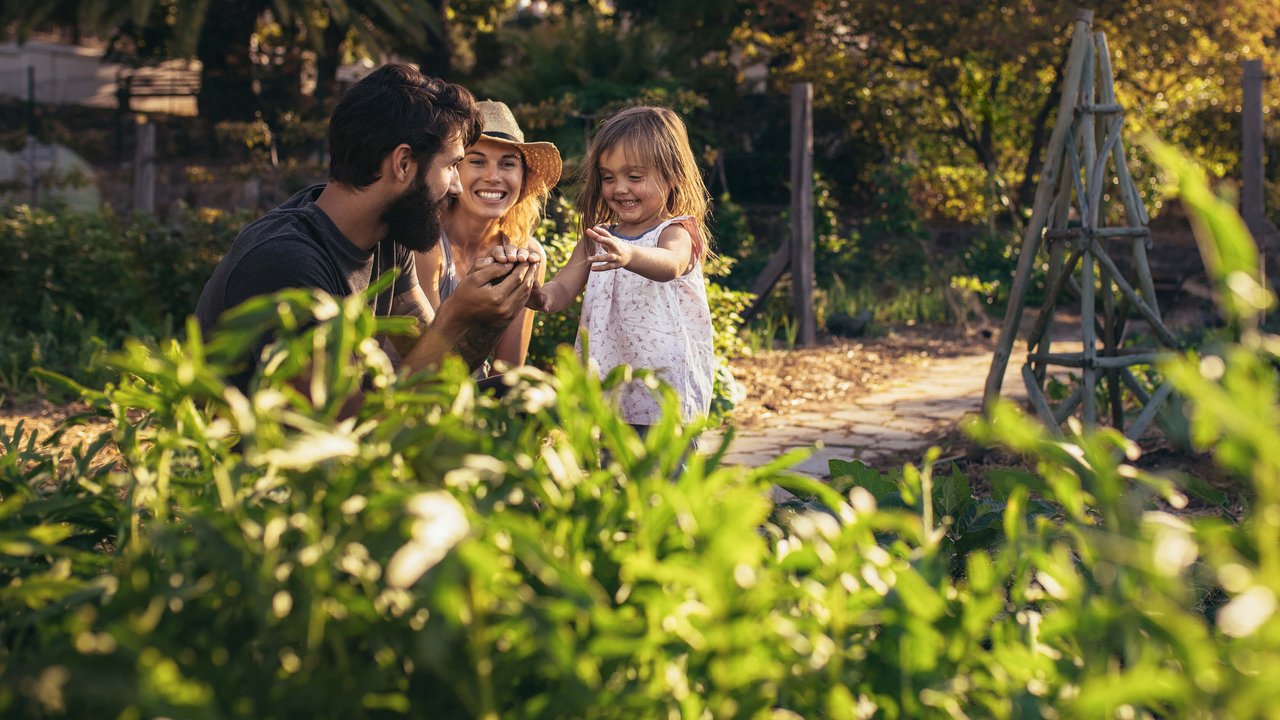 ÖBV fondsgebundene Lebensversicherung Kapital aufbauen, aber wie? Eine Familie spielt im Garten und lacht.