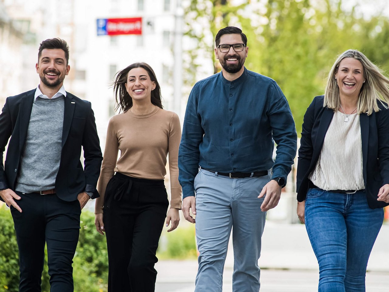 Bild von © Andi Bruckner: Vier Mitarbeiter:innen aus dem ÖBV Vertriebsaußendienst gehen nebeneinander am Gehsteig entlang.