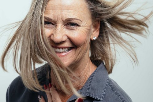 Ältere lachende Frau mit langen Haaren
