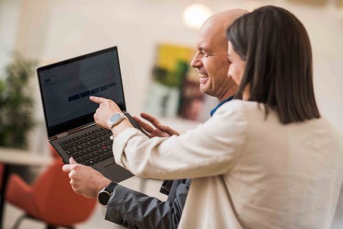 Bild von © Andi Bruckner: Eine ÖBV Vertriebsmitarbeiterin zeigt ihrem Kollegen aus dem Innendienst etwas auf ihrem Laptop.