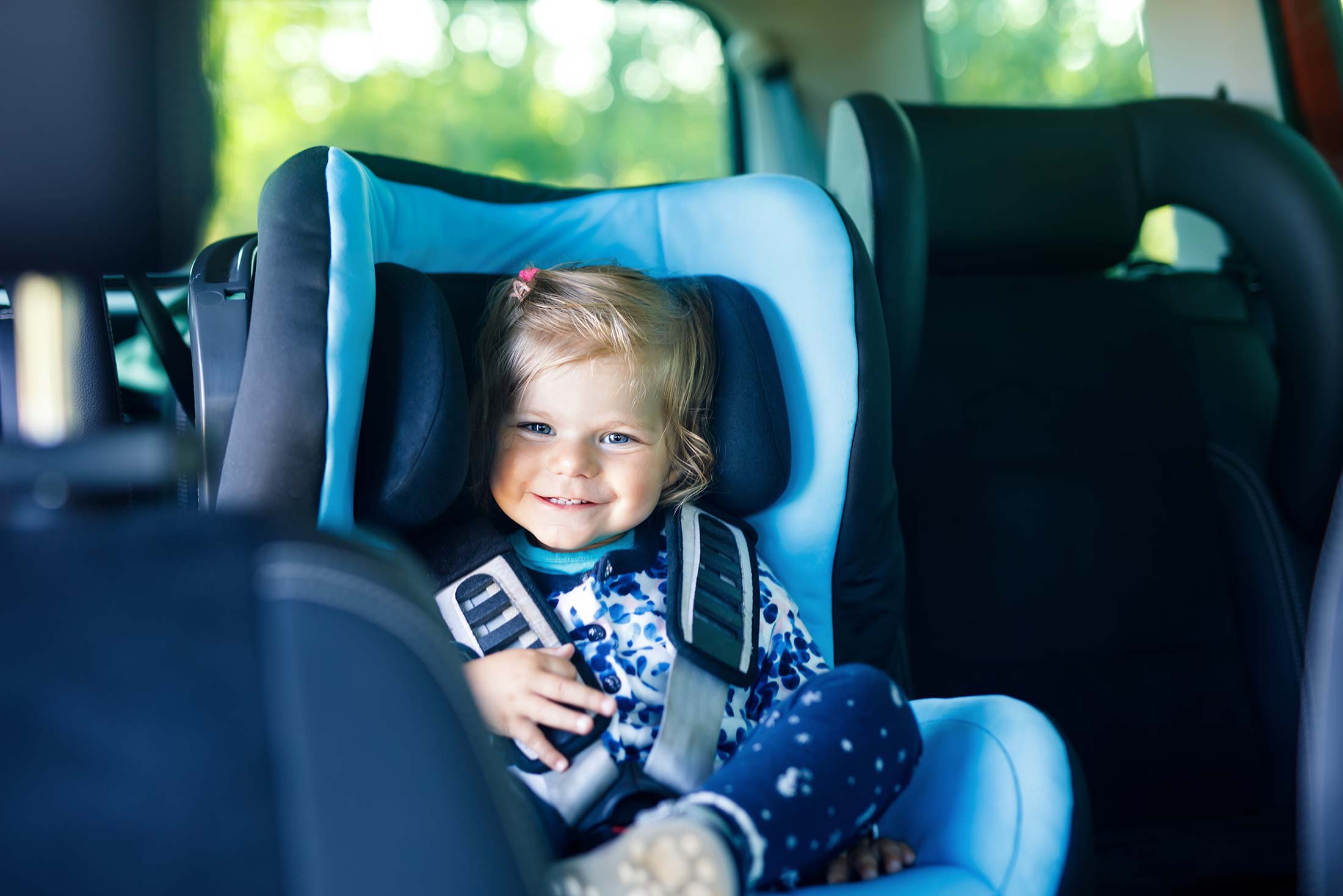 Kleines Mädchen in Auto-Kindersitz