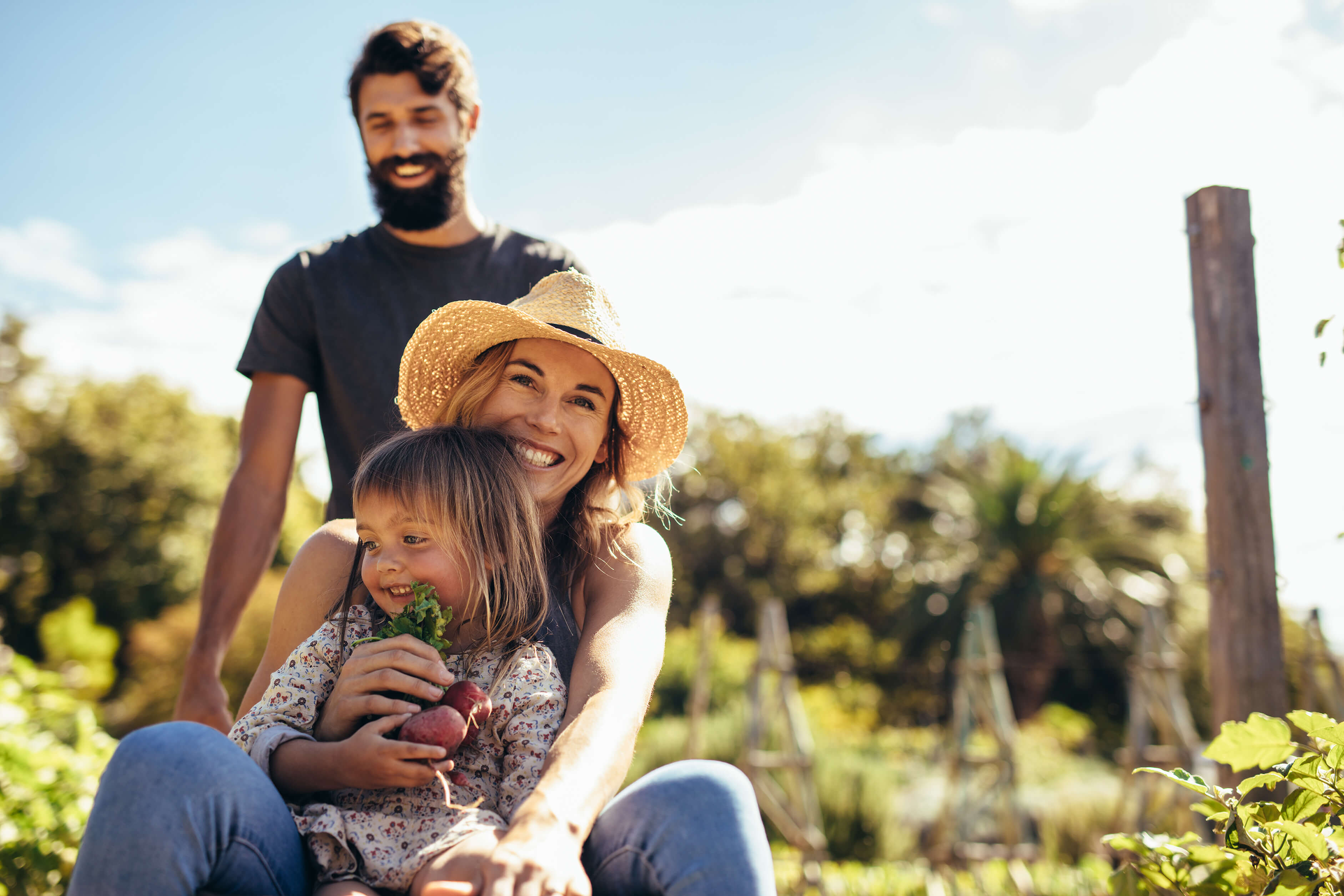 Flexibler Vermögensaufbau mit der ÖBV: Eine Familie sitzt gemeinsam im Grünen und lacht sorgenfrei in die Kamera.