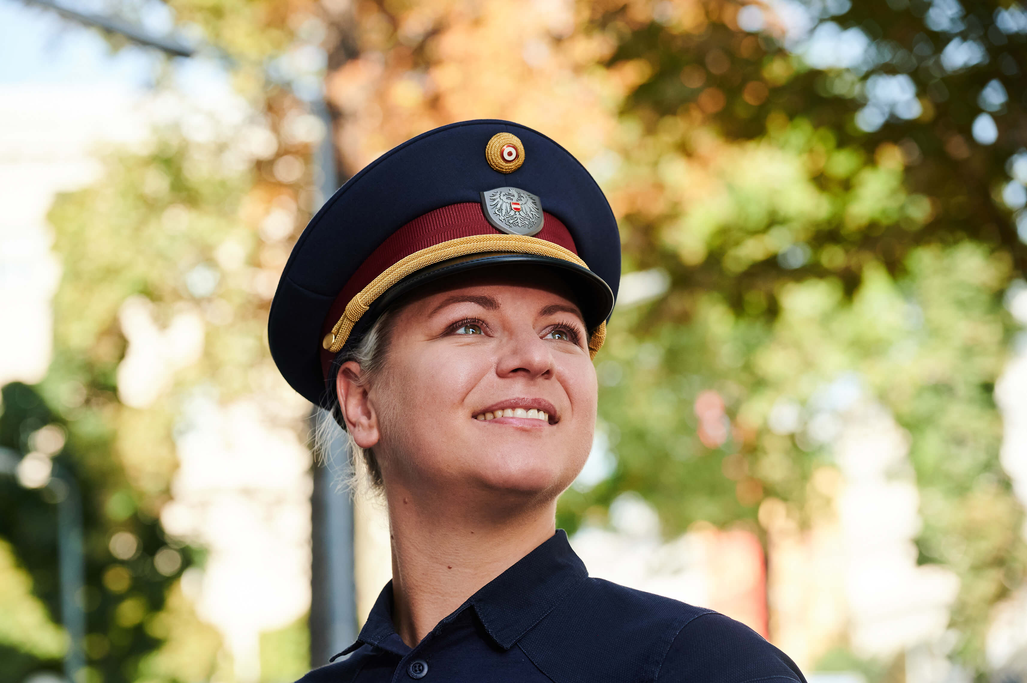 Eine Polizistin steht an der Straße und ist in einer Nahaufnahme zu sehen. Sie lächelt.